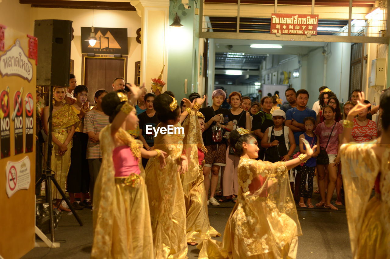 GROUP OF PEOPLE STANDING IN ILLUMINATED SHOP