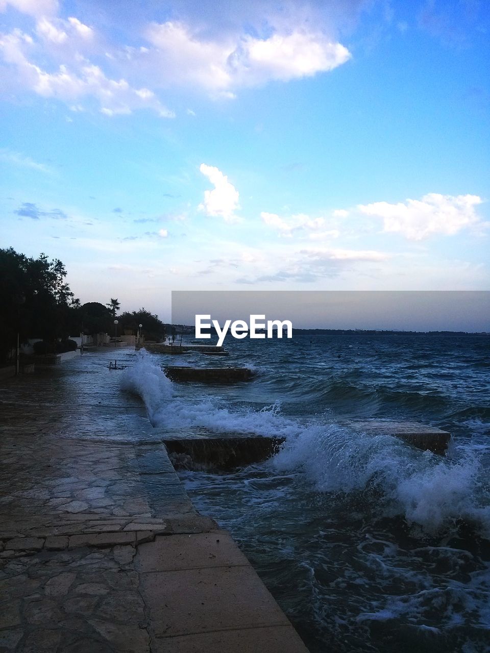 SCENIC VIEW OF BEACH AGAINST CLOUDY SKY