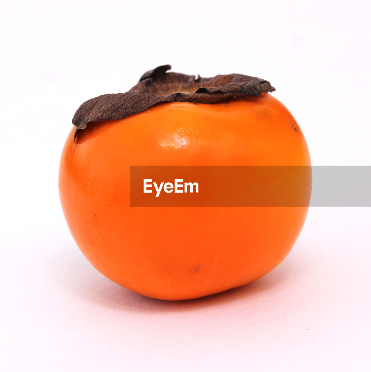 CLOSE-UP OF ORANGE SLICE AGAINST WHITE BACKGROUND