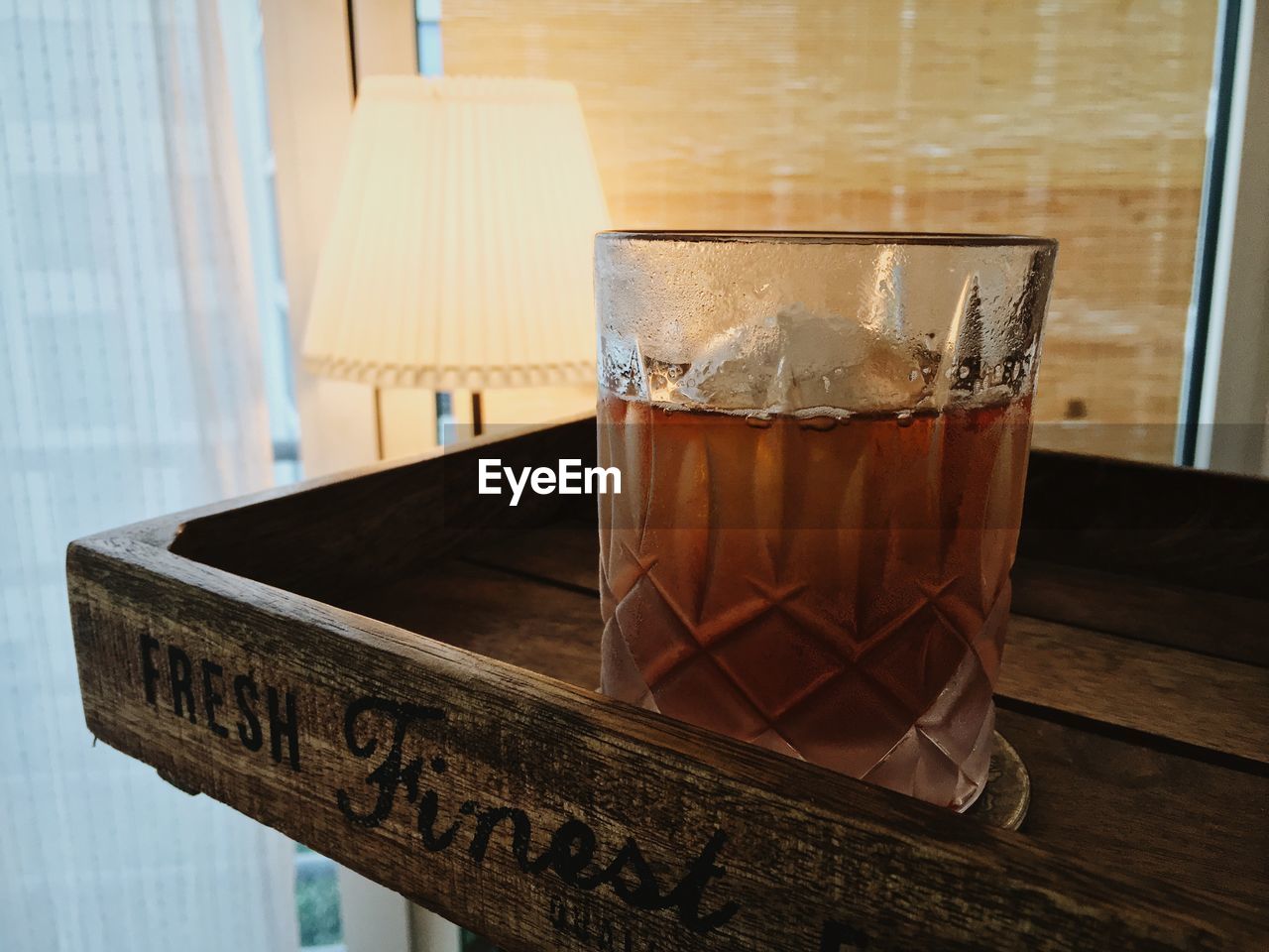 Close-up of alcohol in drinking glass on wooden tray