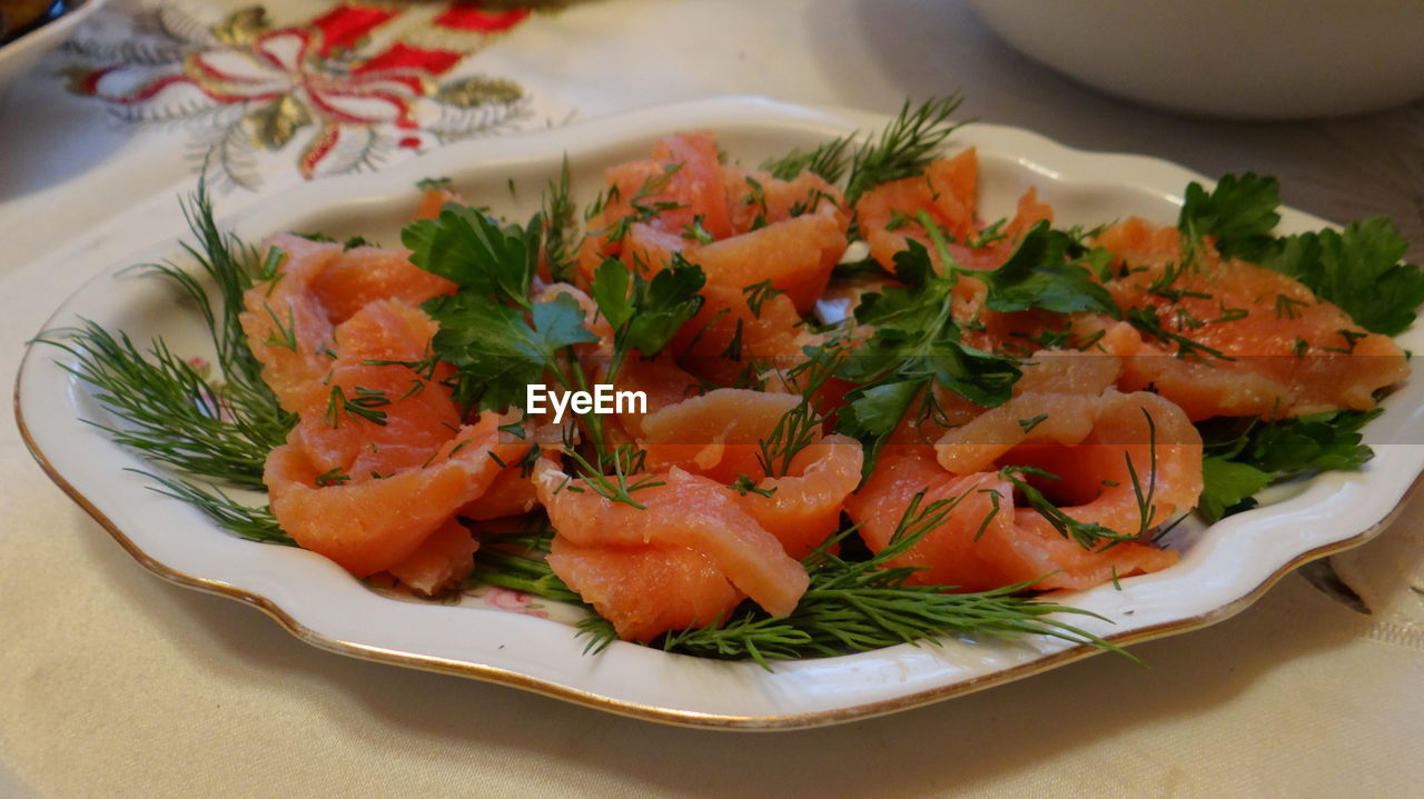 Close-up of salad with salmon in plate on table