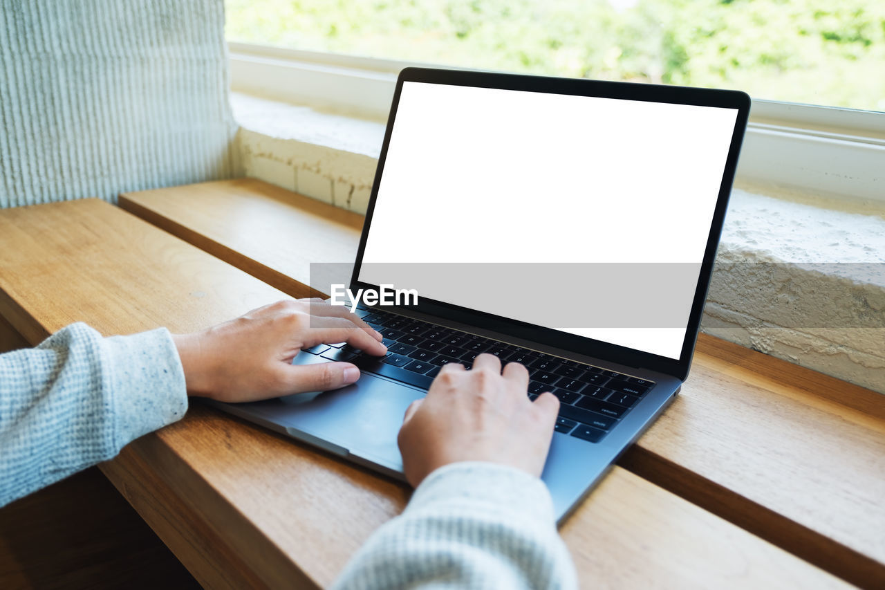 midsection of man using laptop at table