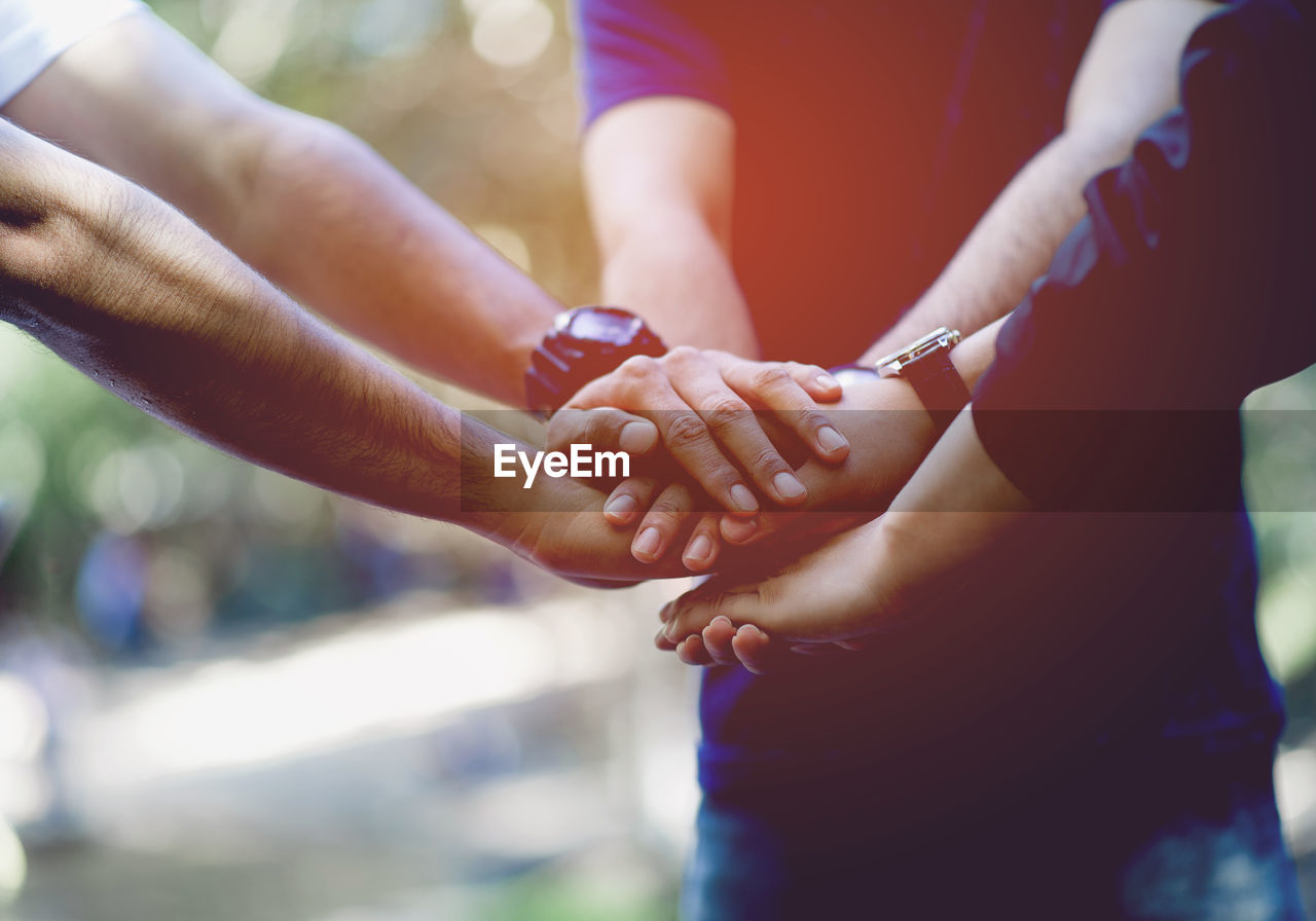 Cropped image of people stacking hands