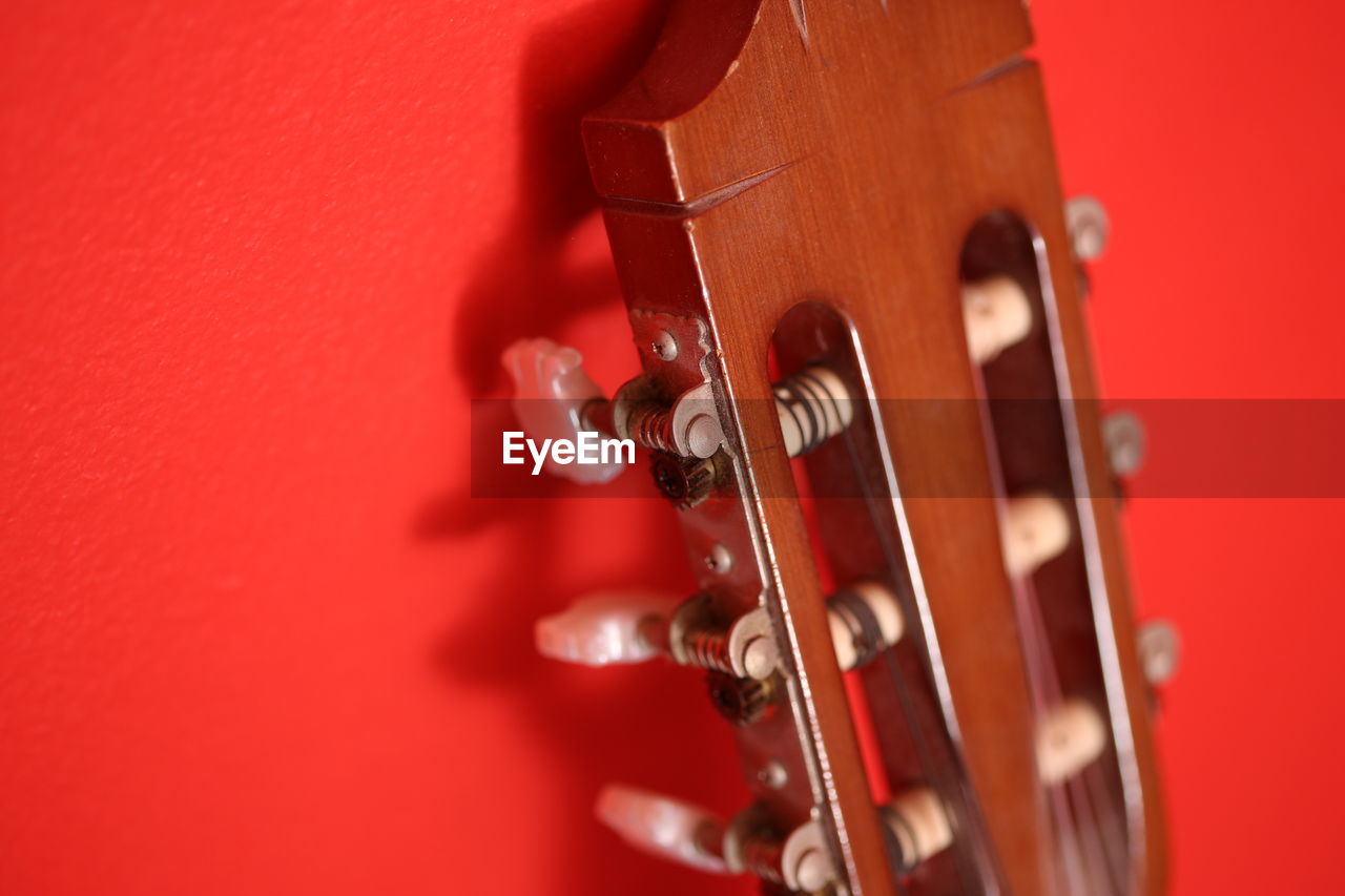 Close-up of guitar against red background