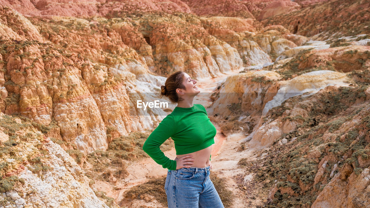 full length of young woman standing on rock