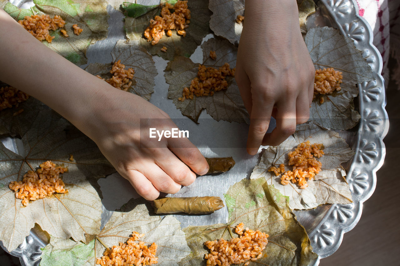 Cropped hands of woman serving food on leaves