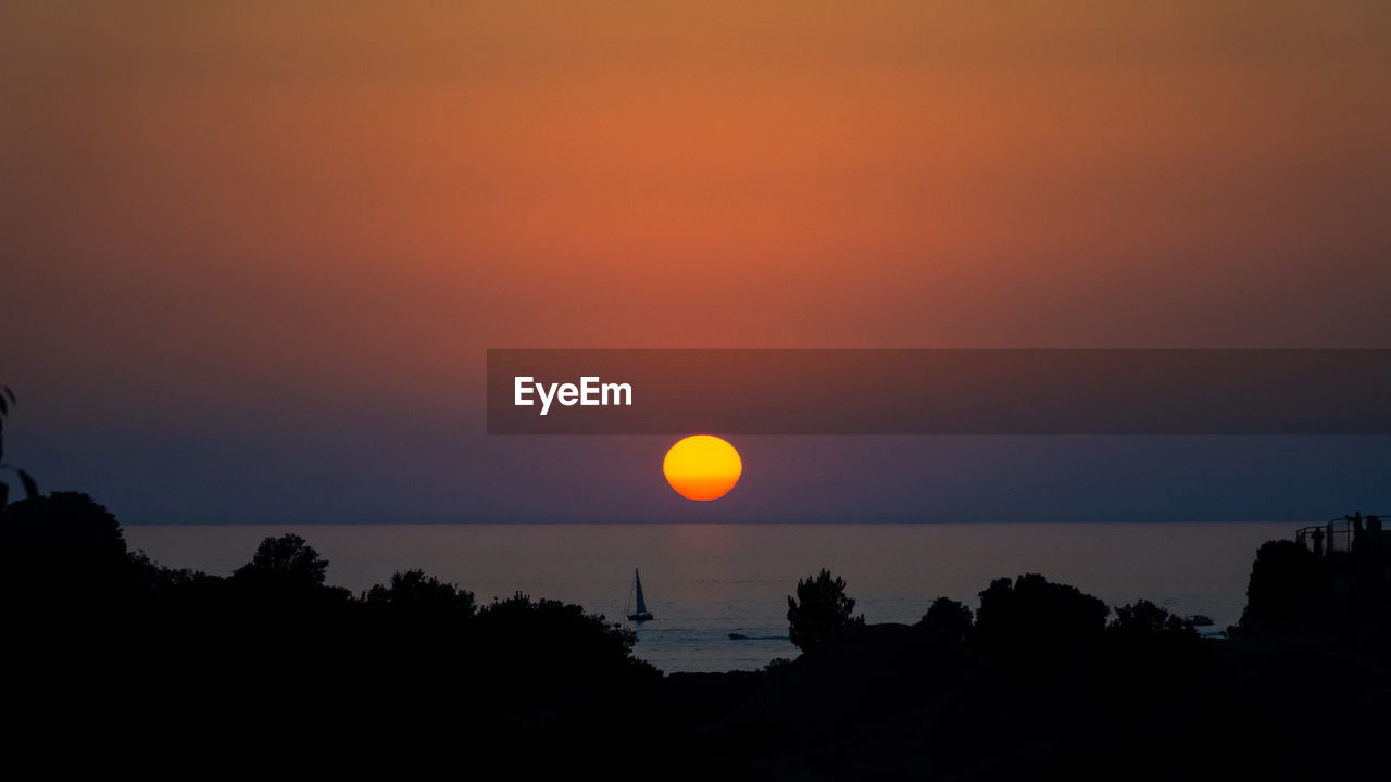 Scenic view of sea against romantic sky at sunset