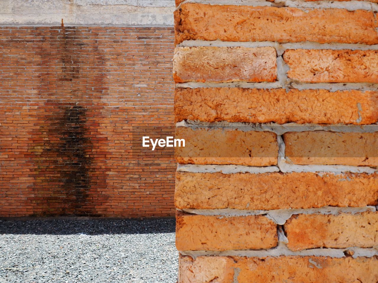 CLOSE-UP OF BRICK WALL ON COBBLESTONE