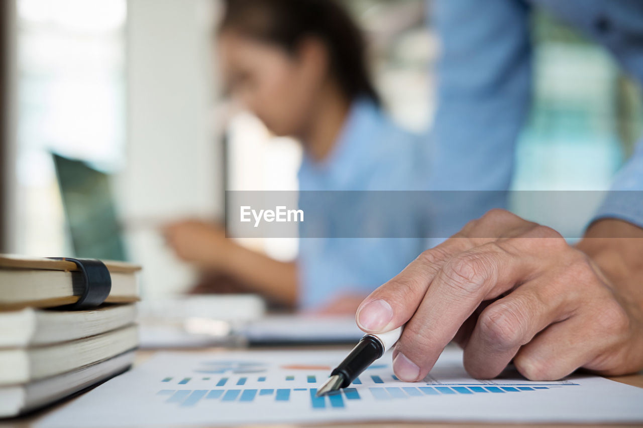 Cropped image of businessman working on graph at office