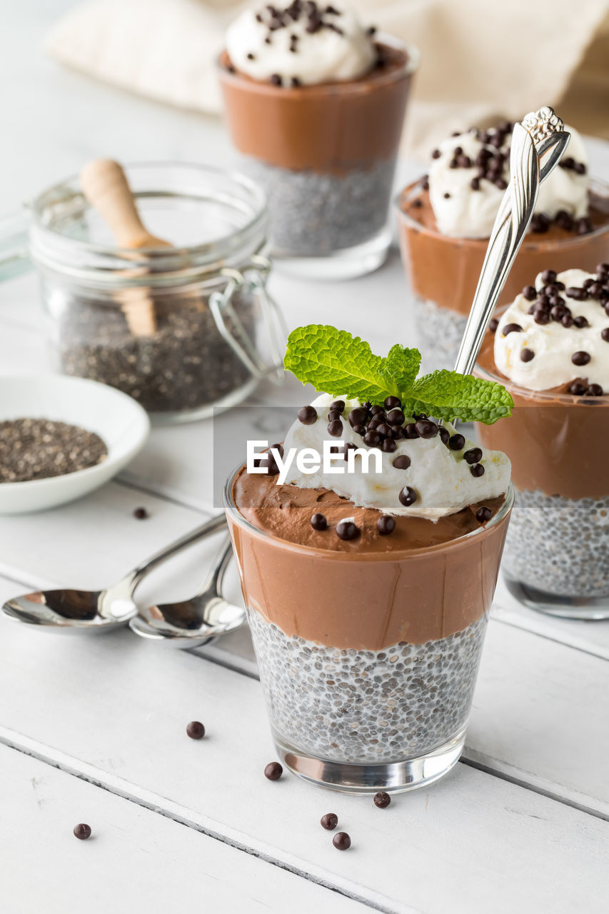 Chocolate chia pudding desserts topped with chocolate covered quinoa puffs.