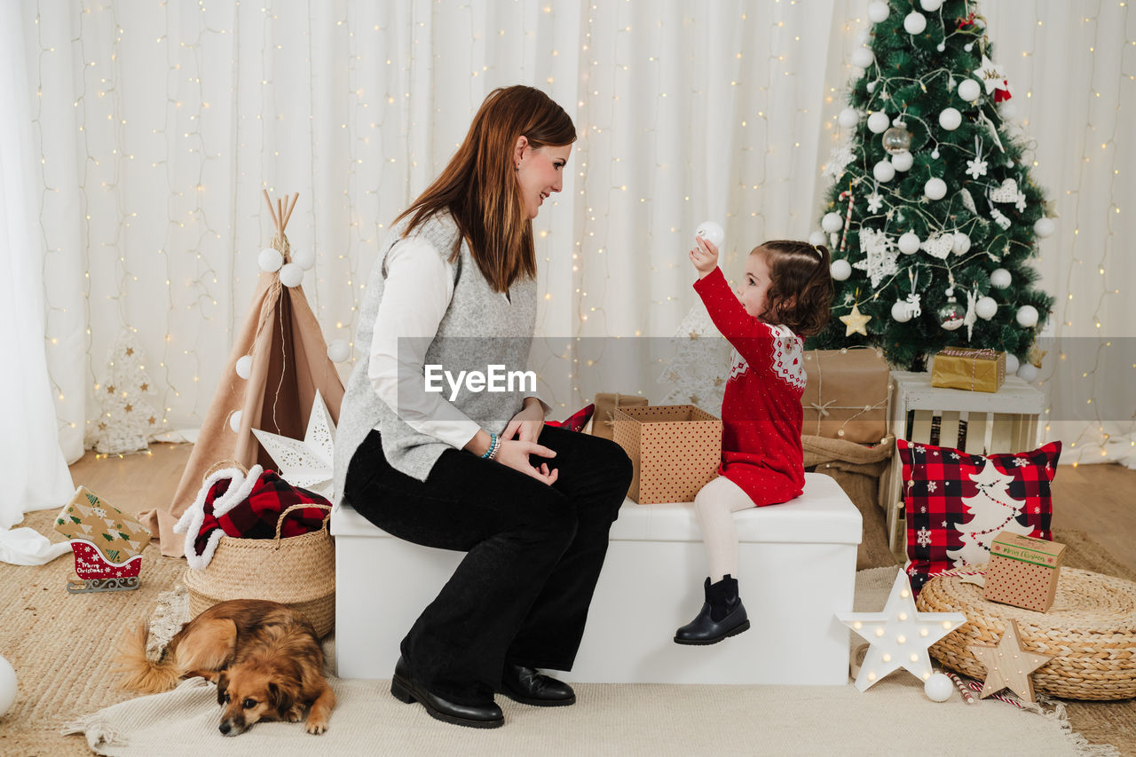 Smiling mother and daughter at home enjoying christmas time at home