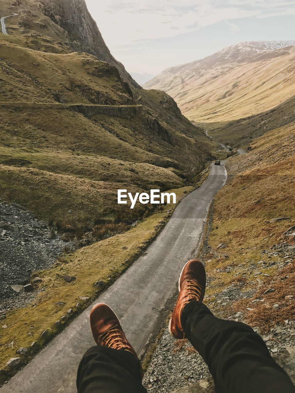 Low section of man over road against mountain