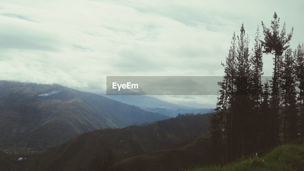 Scenic view of mountains against cloudy sky