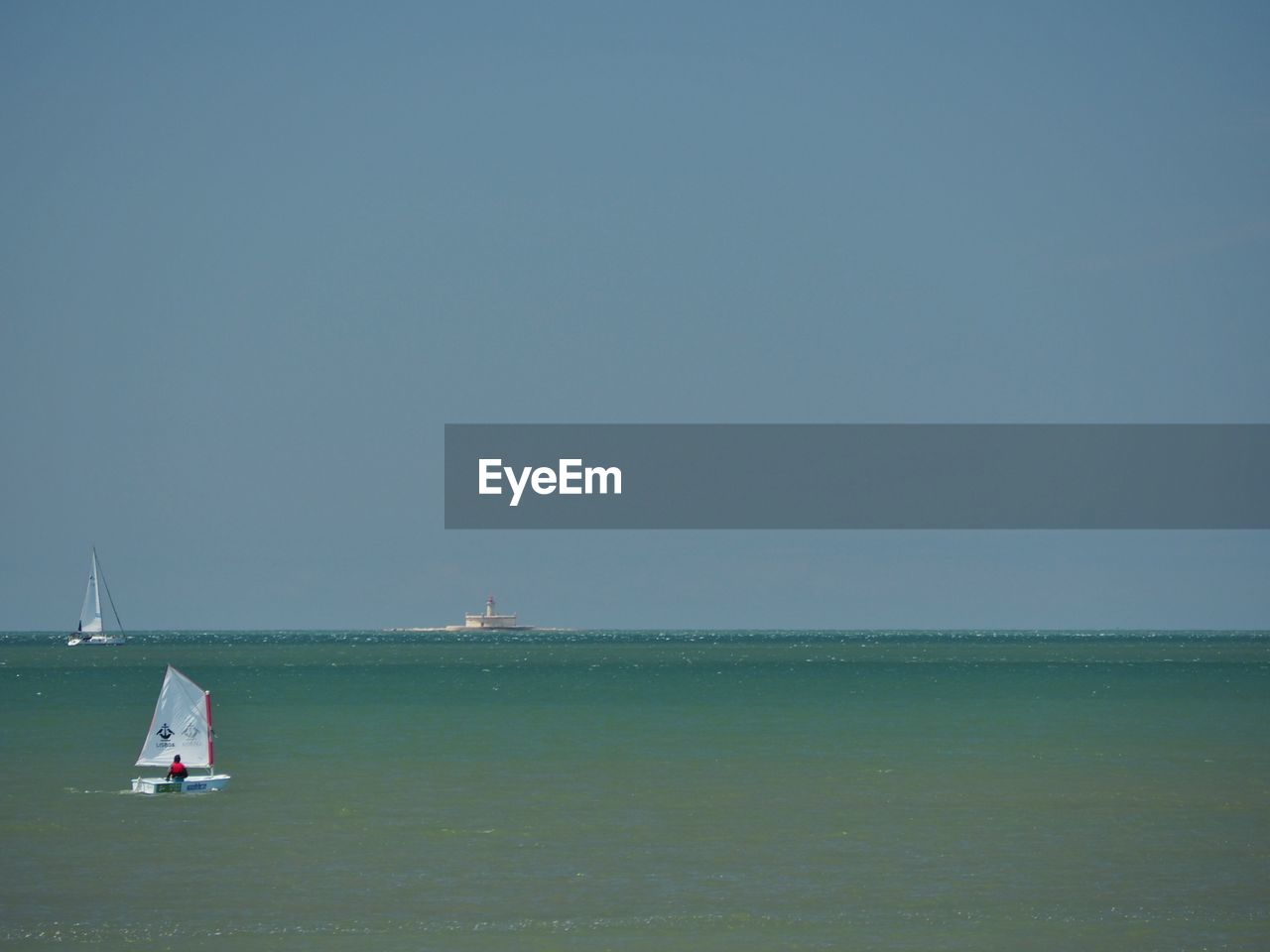 Sailboat sailing on sea against clear sky