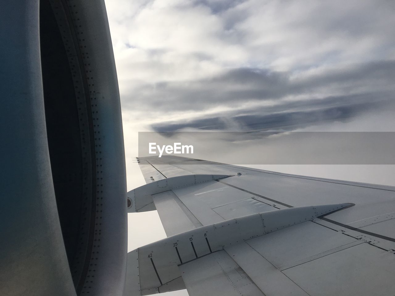 Cropped image of airplane flying over cloudscape against sky