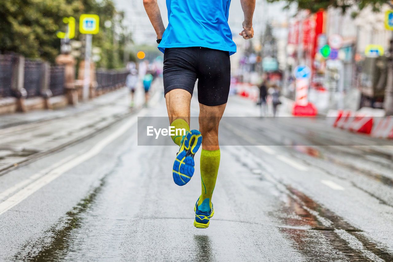 low section of man walking on road