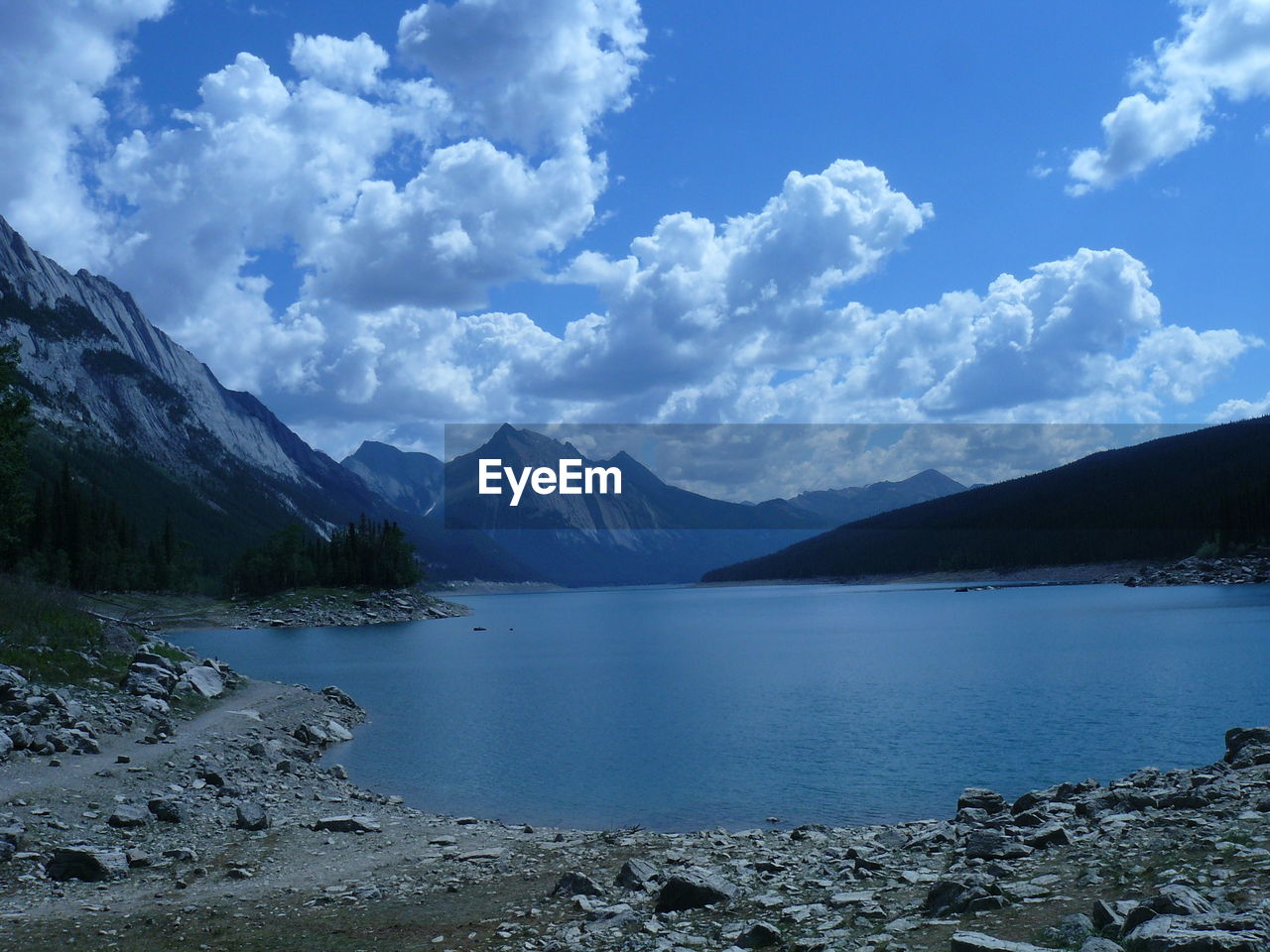 Scenic view of river and mountains against sky