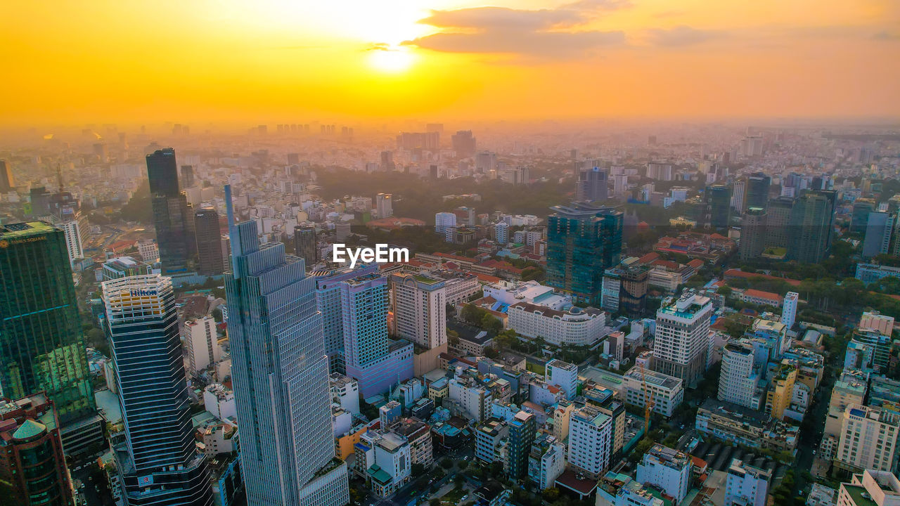 high angle view of buildings in city during sunset