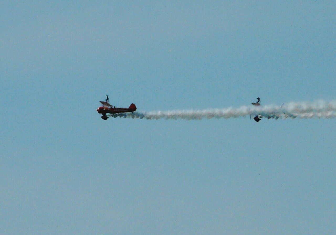 Low angle view of biplanes flying against clear sky