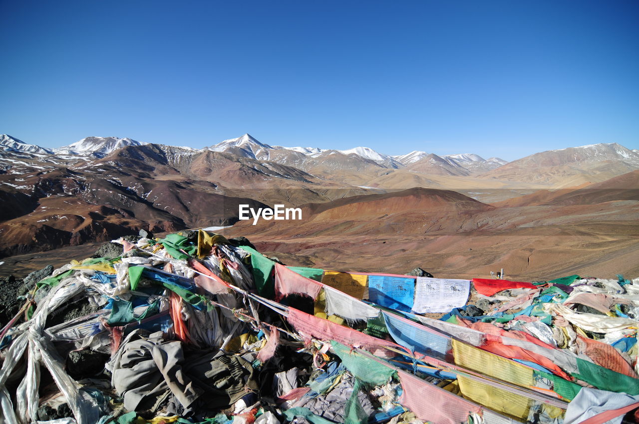 Prayer flags on mountain against clear blue sky