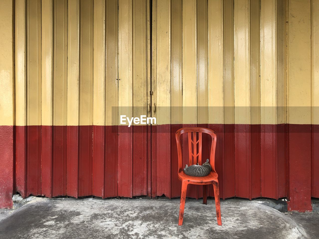 Empty chair against red wall