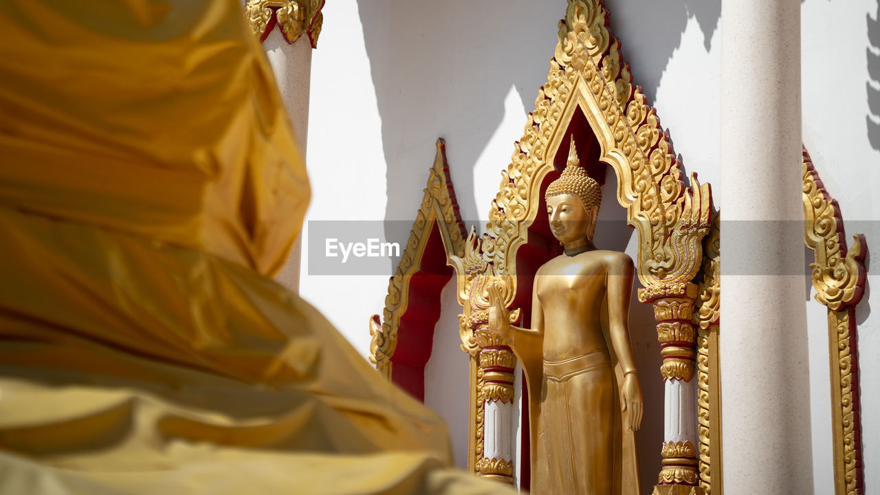 LOW ANGLE VIEW OF STATUES AGAINST BUILDING