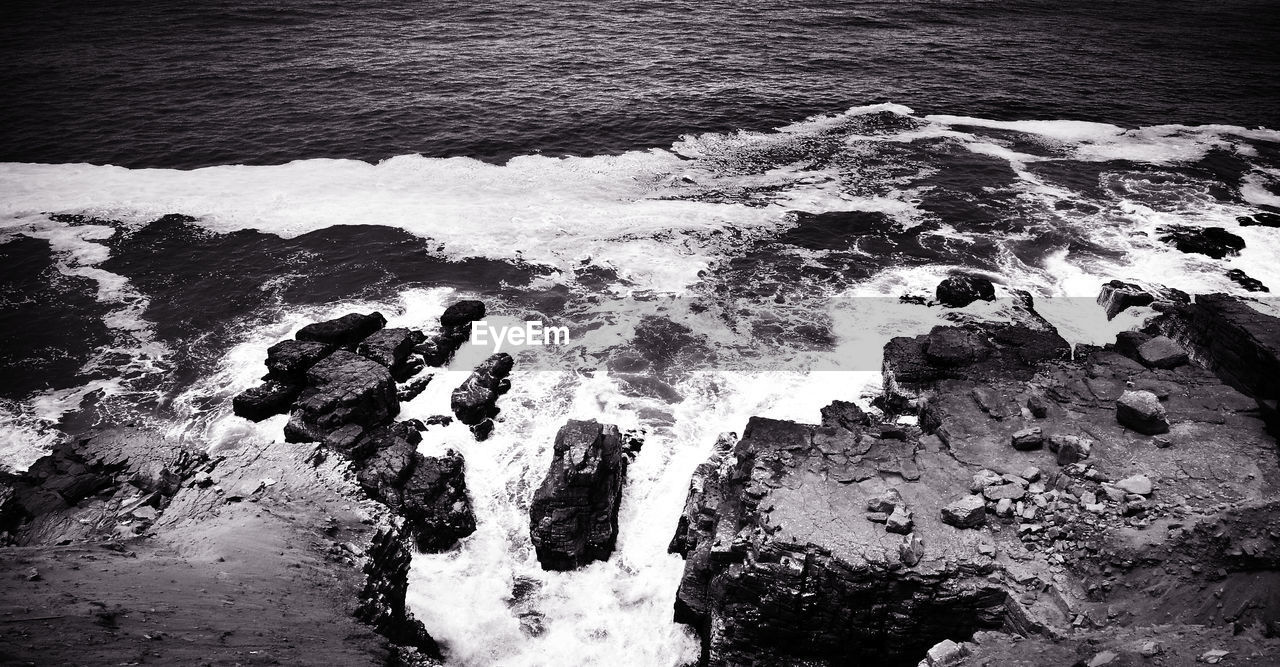 HIGH ANGLE VIEW OF ROCK ON BEACH