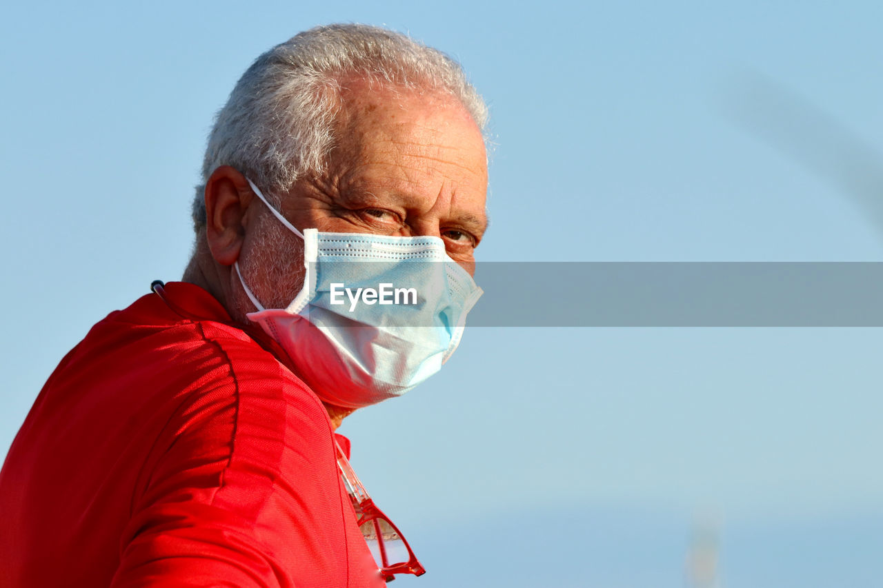 LOW ANGLE PORTRAIT OF MAN AGAINST SKY