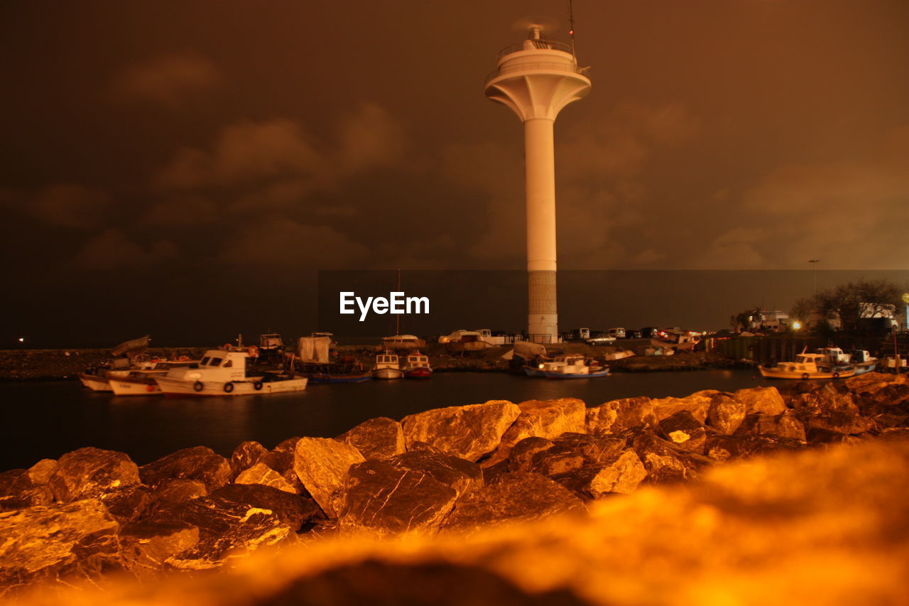 VIEW OF ILLUMINATED CITY AGAINST CLOUDY SKY