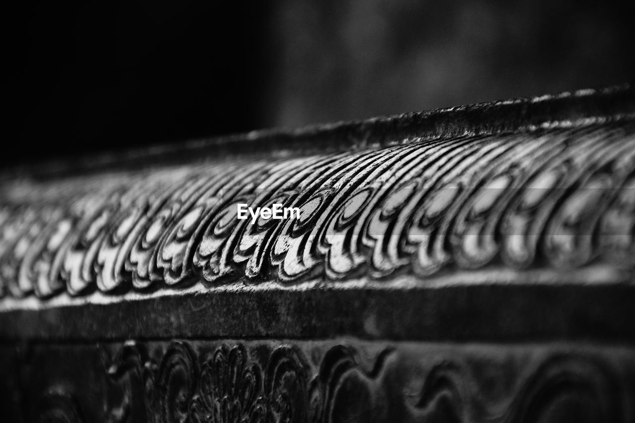 Close-up of carvings on cropped machinery in factory