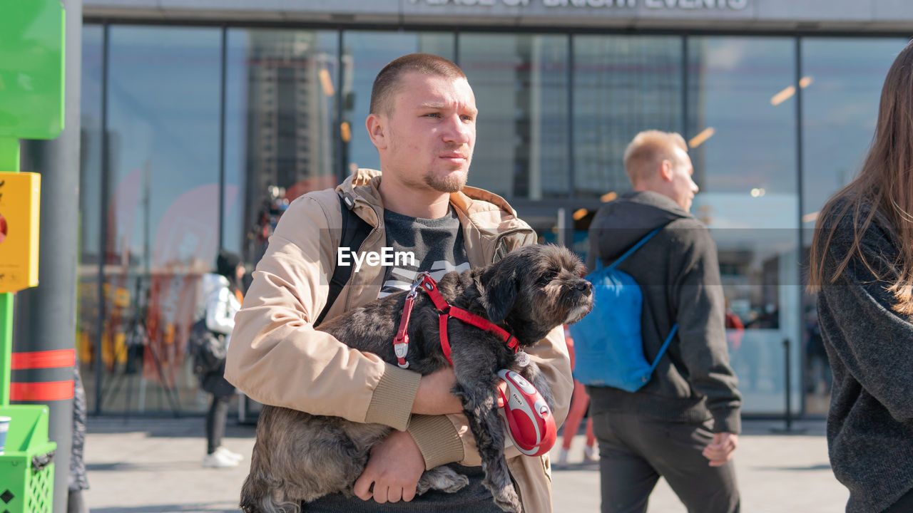 REAR VIEW OF PEOPLE WITH DOG ON THE BACKGROUND