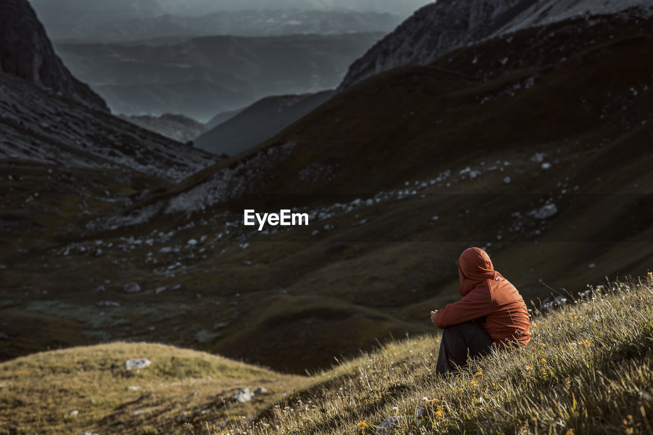 Man sitting on mountain during winter