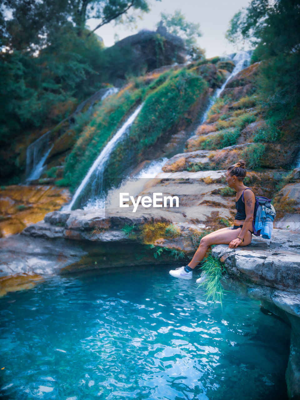 Man surfing on rock in water