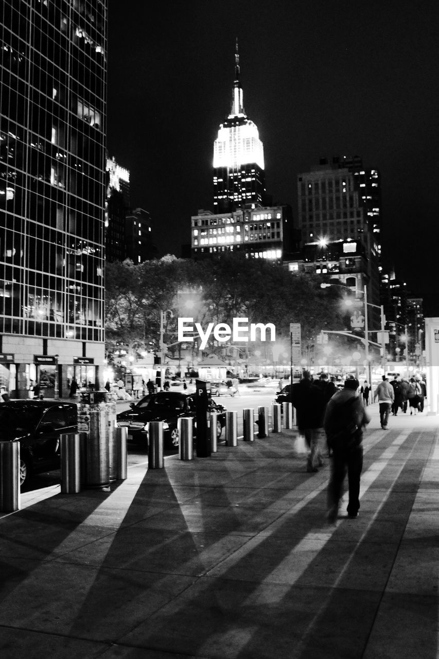 Low angle view of empire state building in city at night