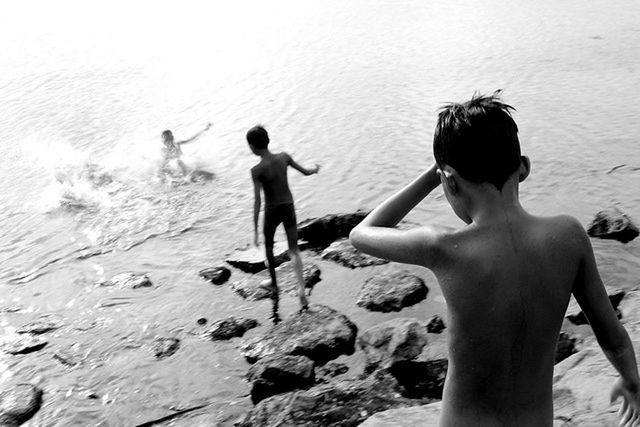 Rear view of children enjoying at beach