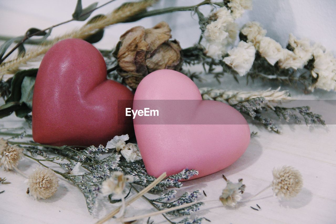 Close-up of heart shape soaps with flowers on table