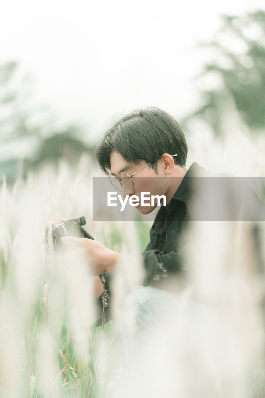 Portrait of man with his camera in the middle of white reeds