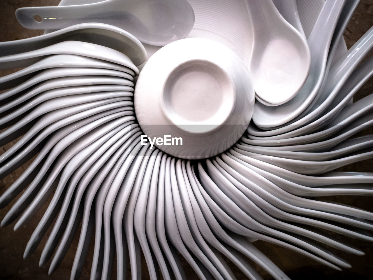 Close-up view of ceramic spoons arranged in a circle formation