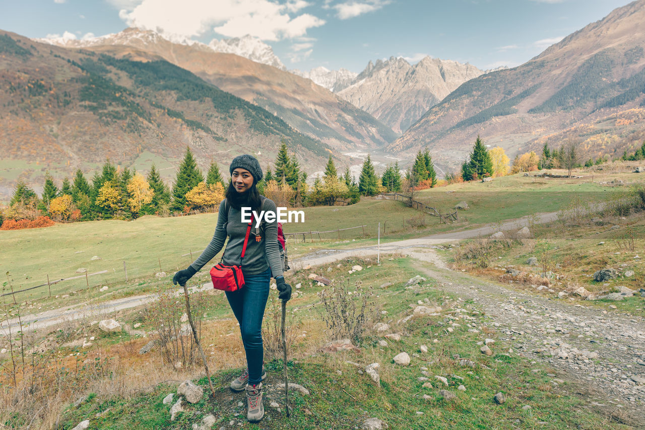 Asian woman is hiking in colorful nature scenic of forest and hills.