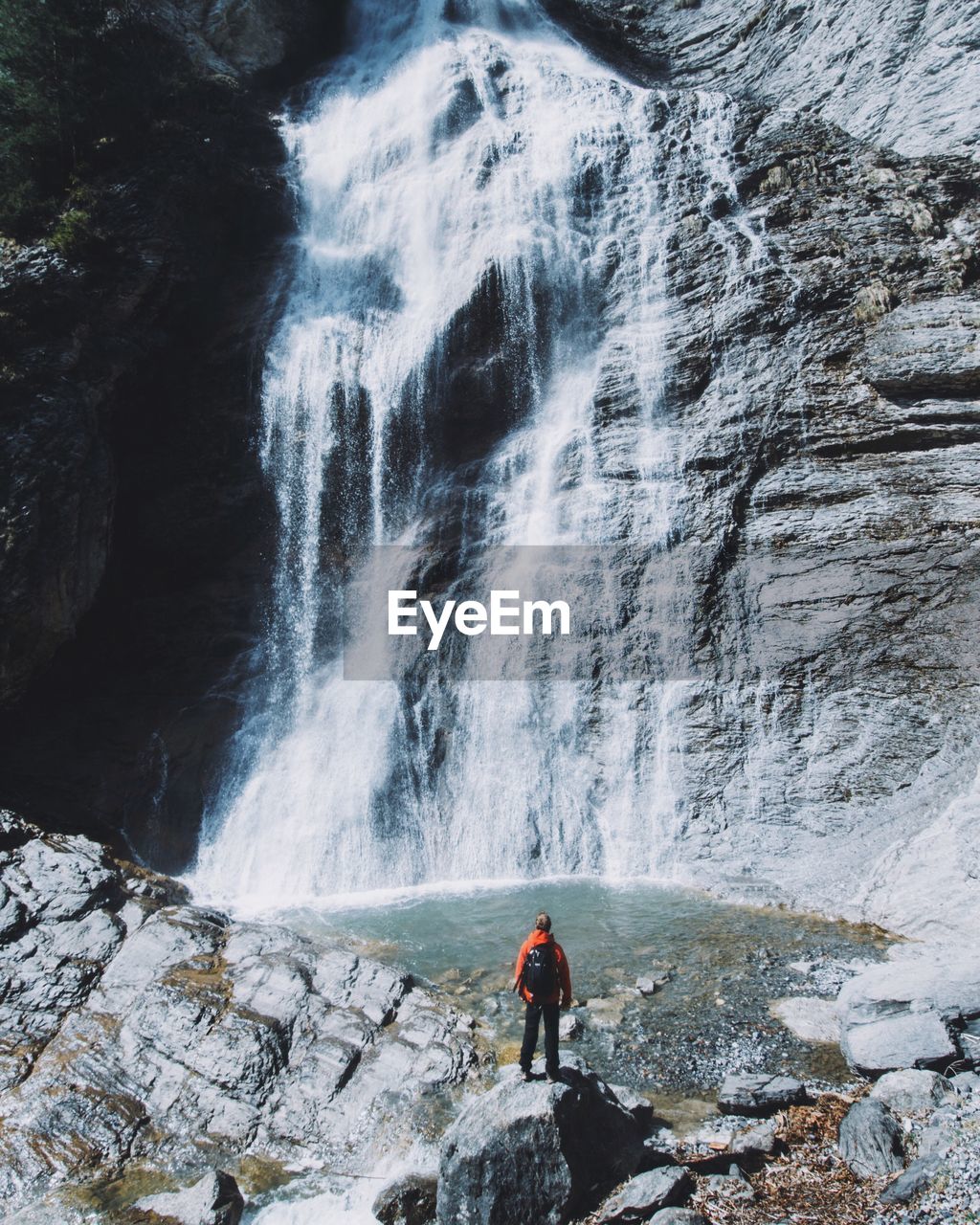 Rear view of person looking at waterfall