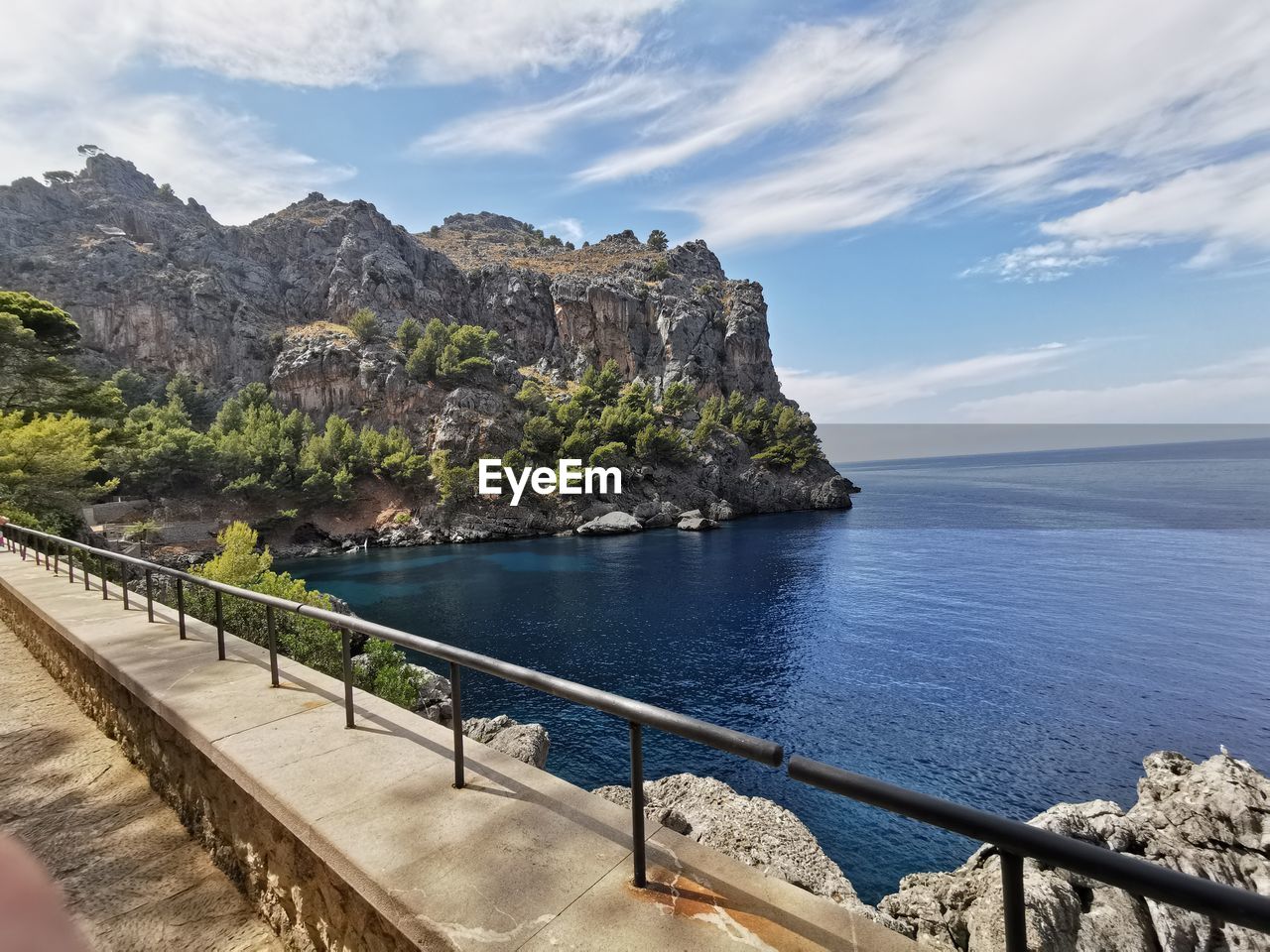 SCENIC VIEW OF SEA BY ROCK FORMATION AGAINST SKY