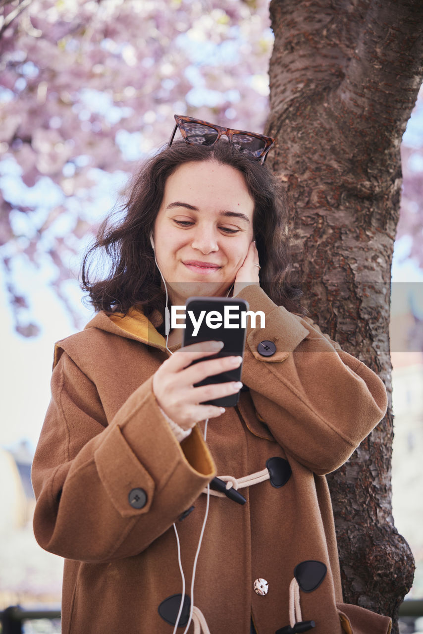 Young woman listening to music from phone