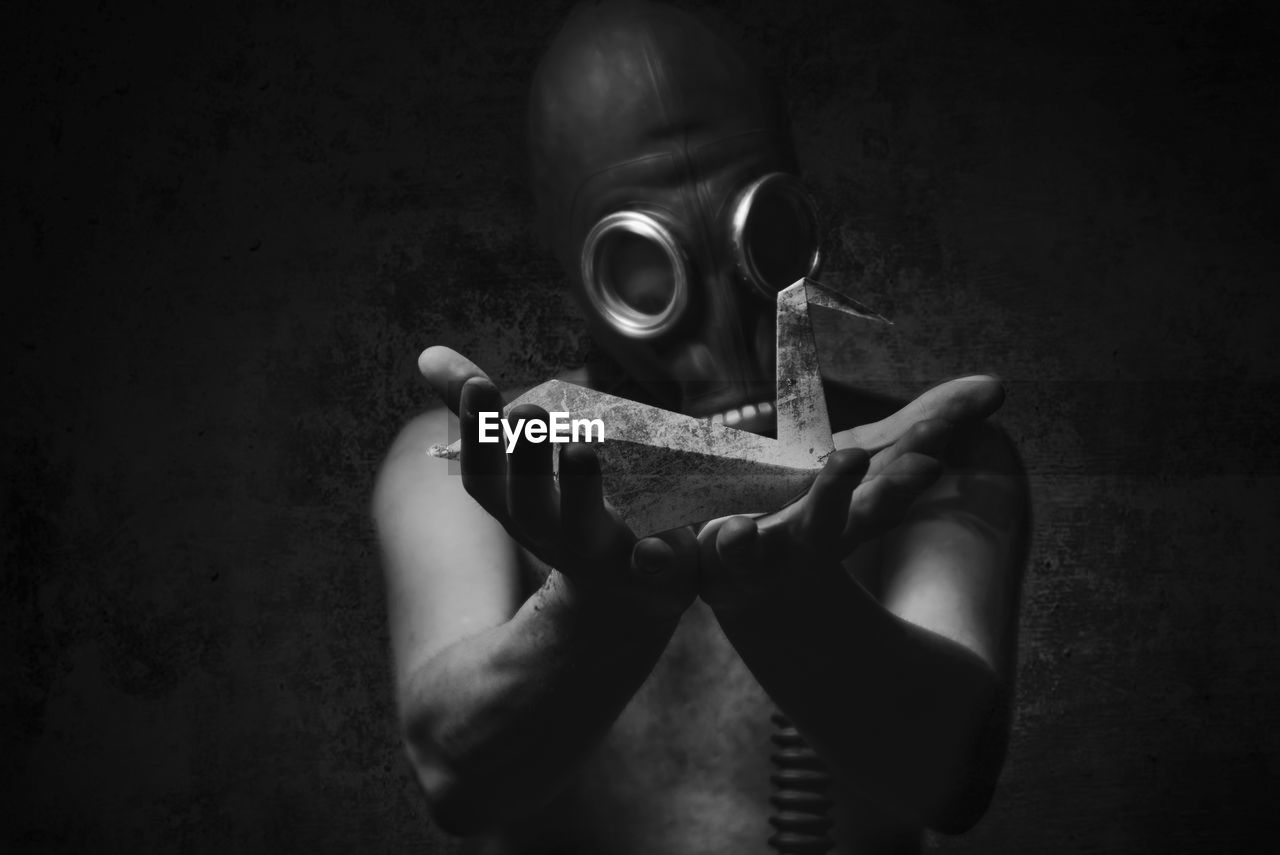 Man wearing gas mask in darkroom
