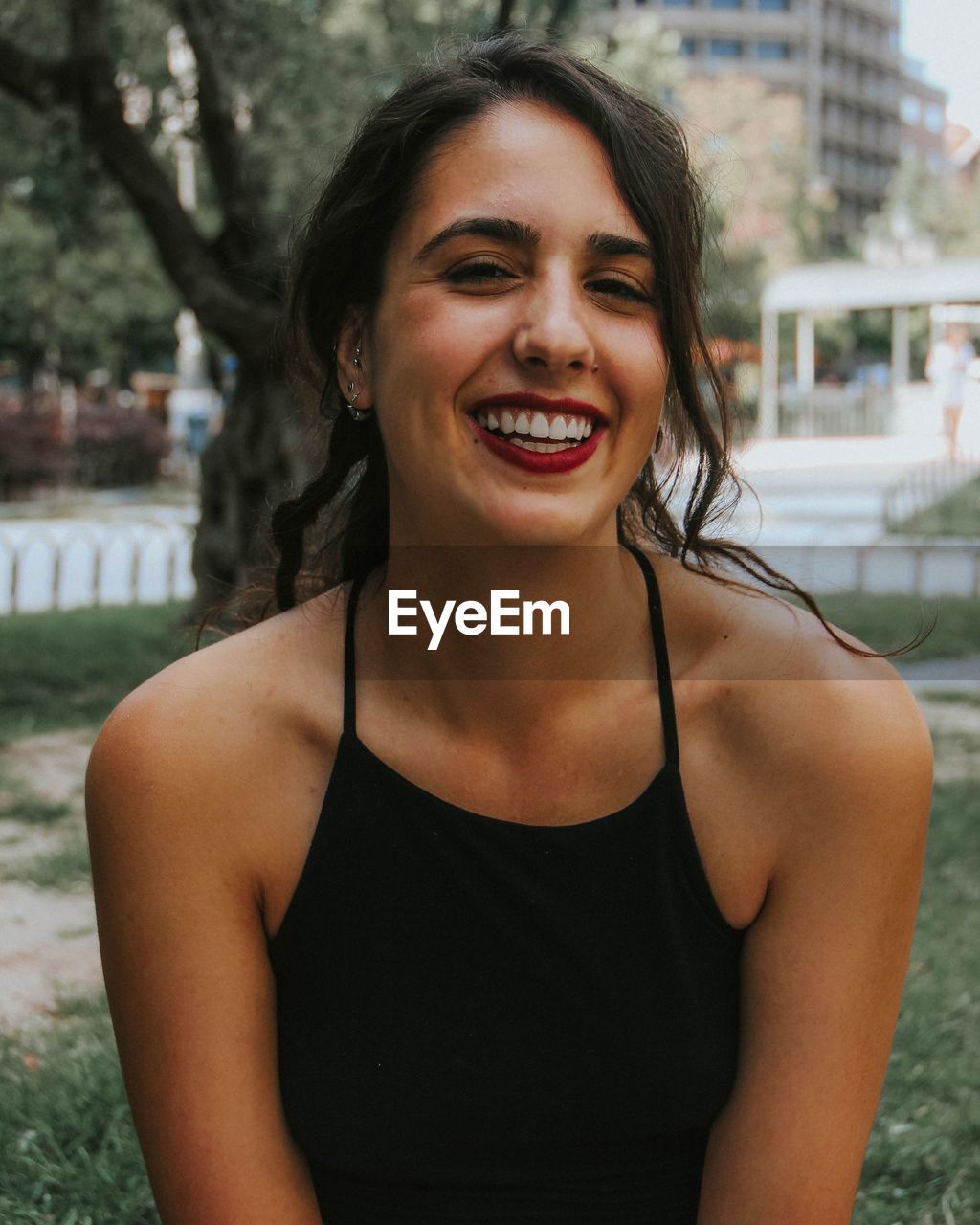 Close-up portrait of cheerful young woman at park