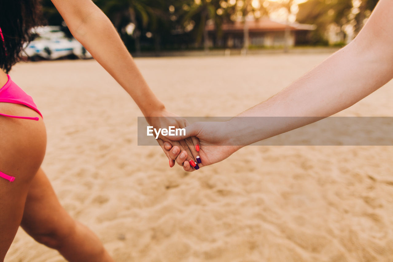 Couple holding hands on beach