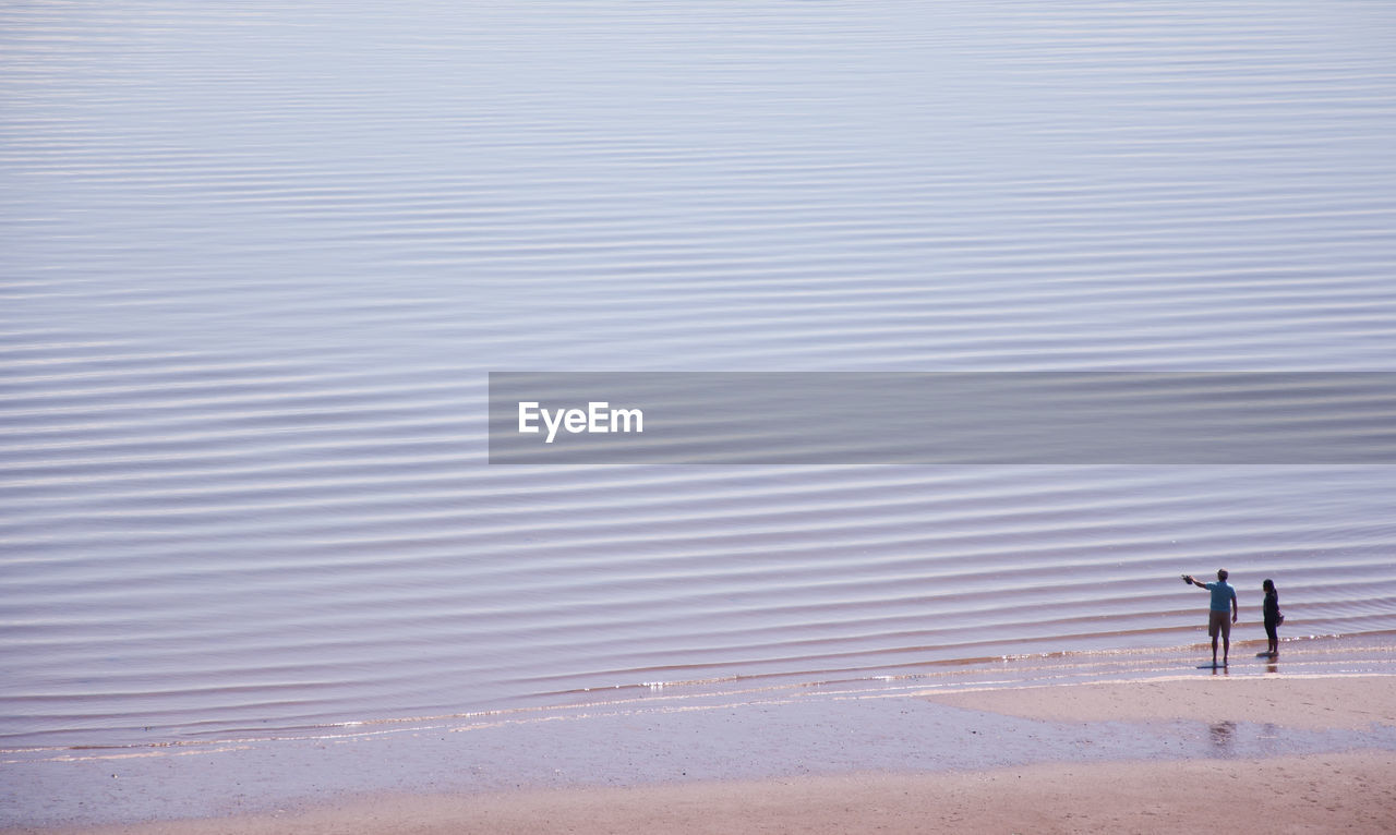 High angle view of couple standing on beach