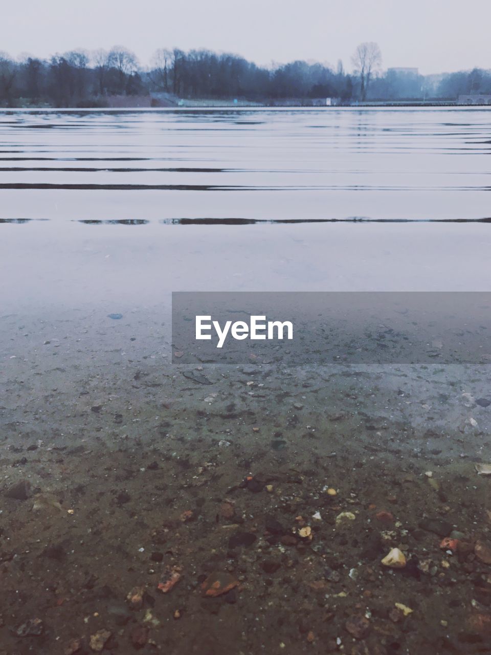 FROZEN LAKE AGAINST SKY IN WINTER