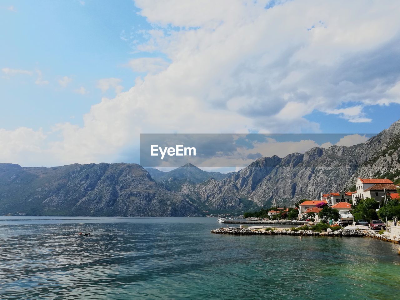 Scenic view of sea by mountains against sky