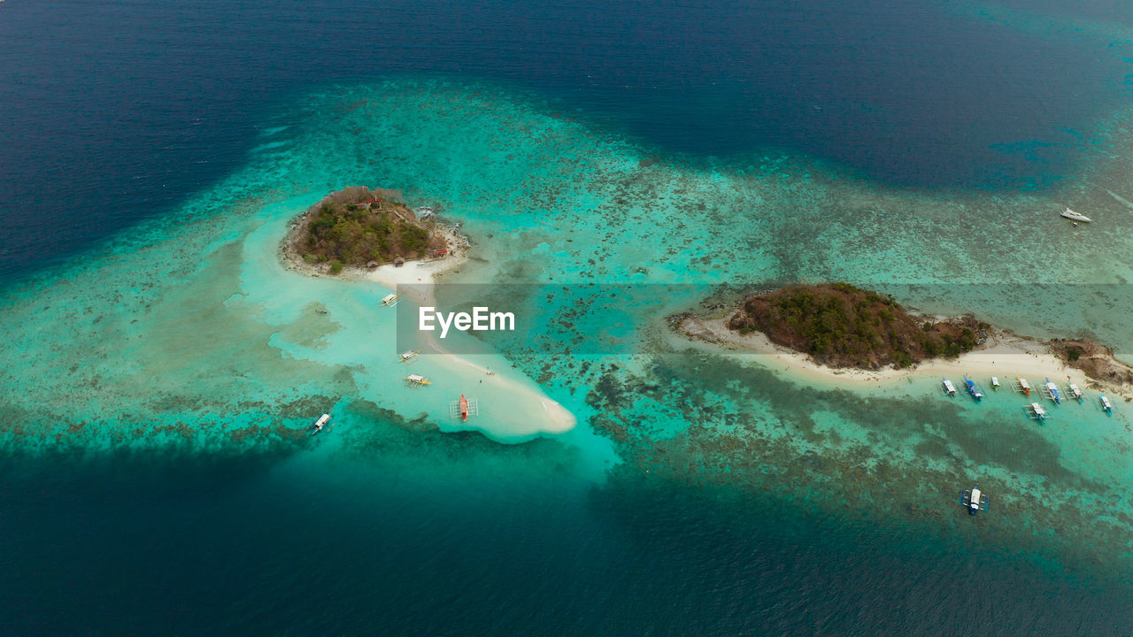 Aerial seascape bay with tropical island and sand beach, turquoise water and coral reef. bulog dos