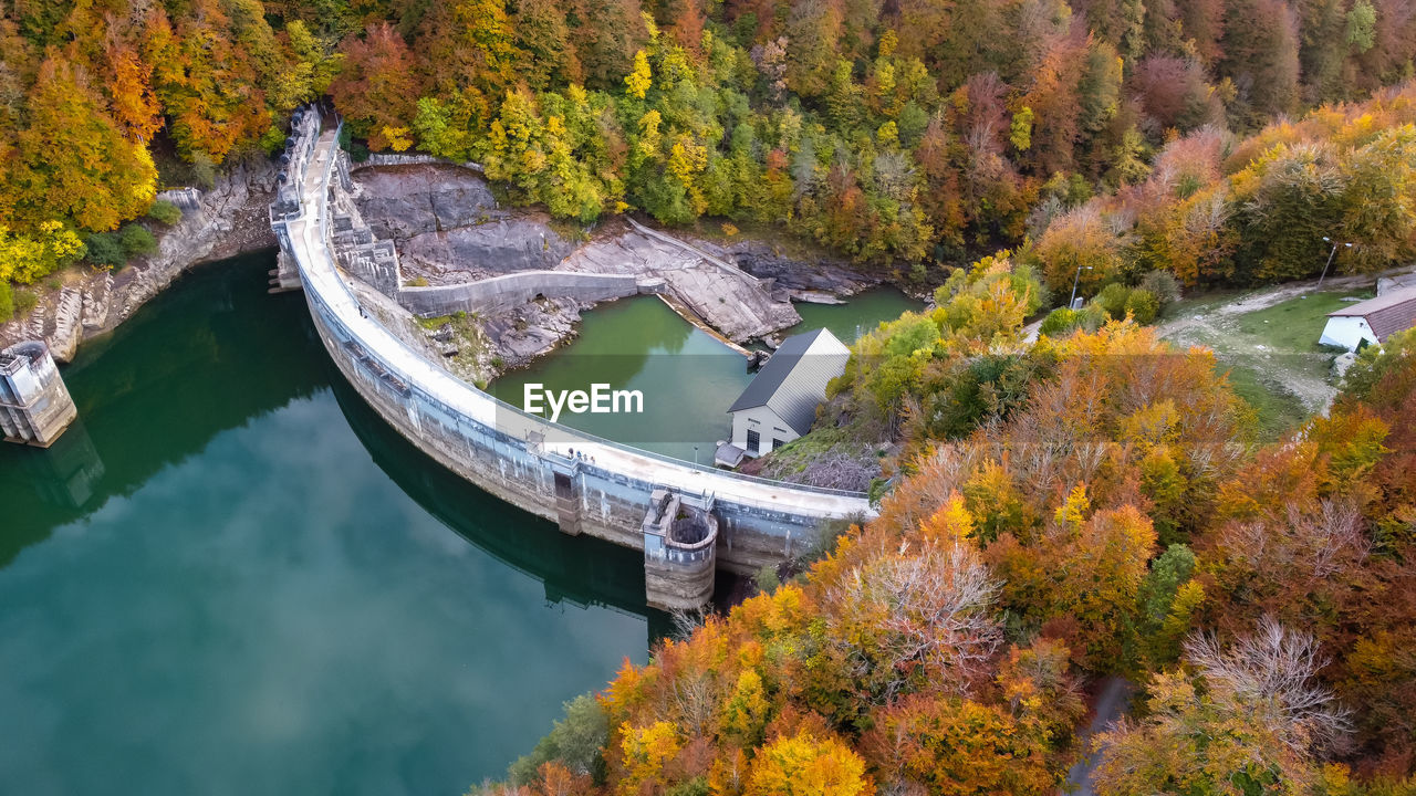 Aerial view hydraulic dam with surrounding forest in autumn
